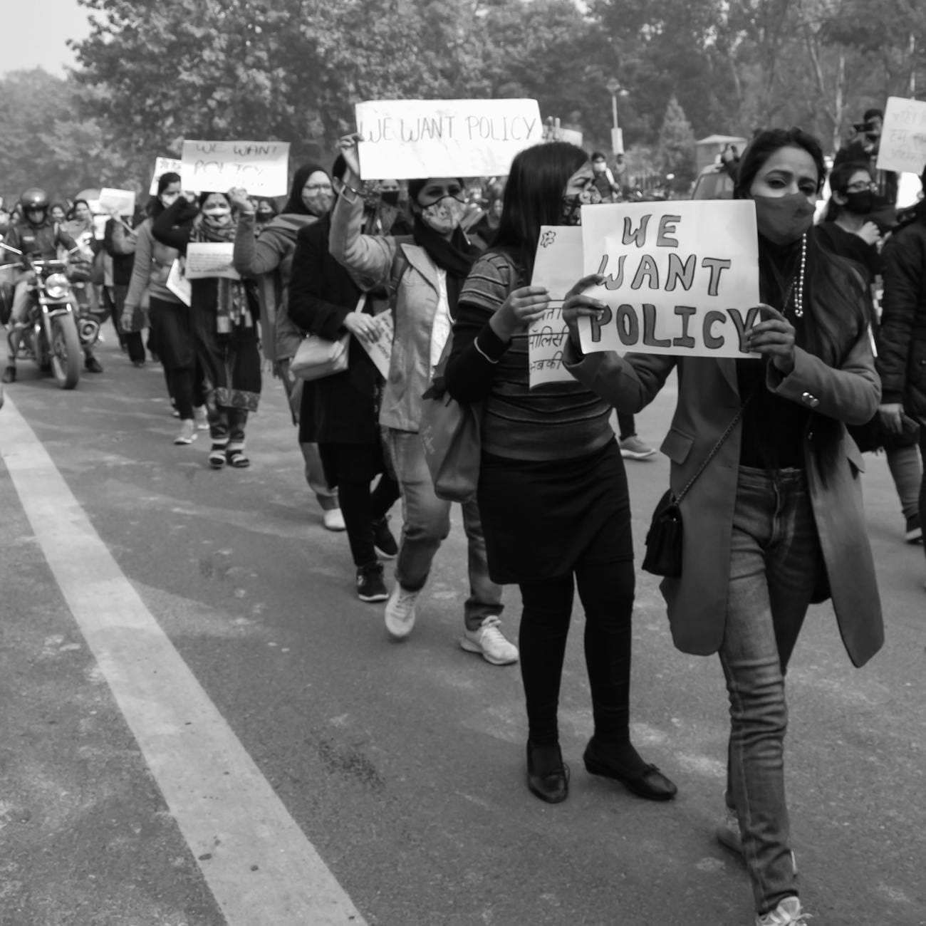 Czarno-biały tłum demonstrantów z transparentami We Want Policy