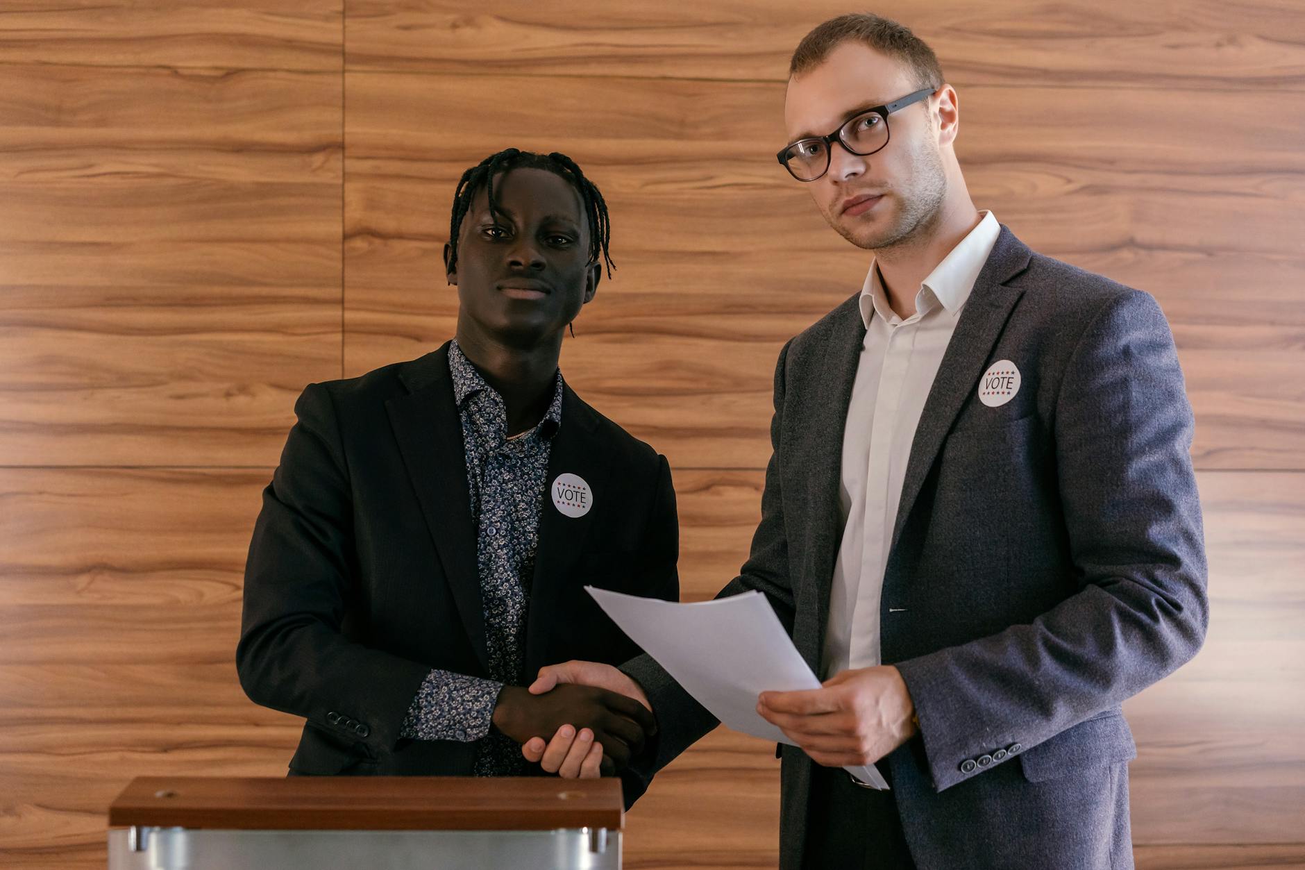 Dwaj mężczyźni w garniturach ściskają dłonie w kampanii wyborczej