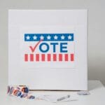 Urna wyborcza z kartą do głosowania i naklejkami wyborczymi