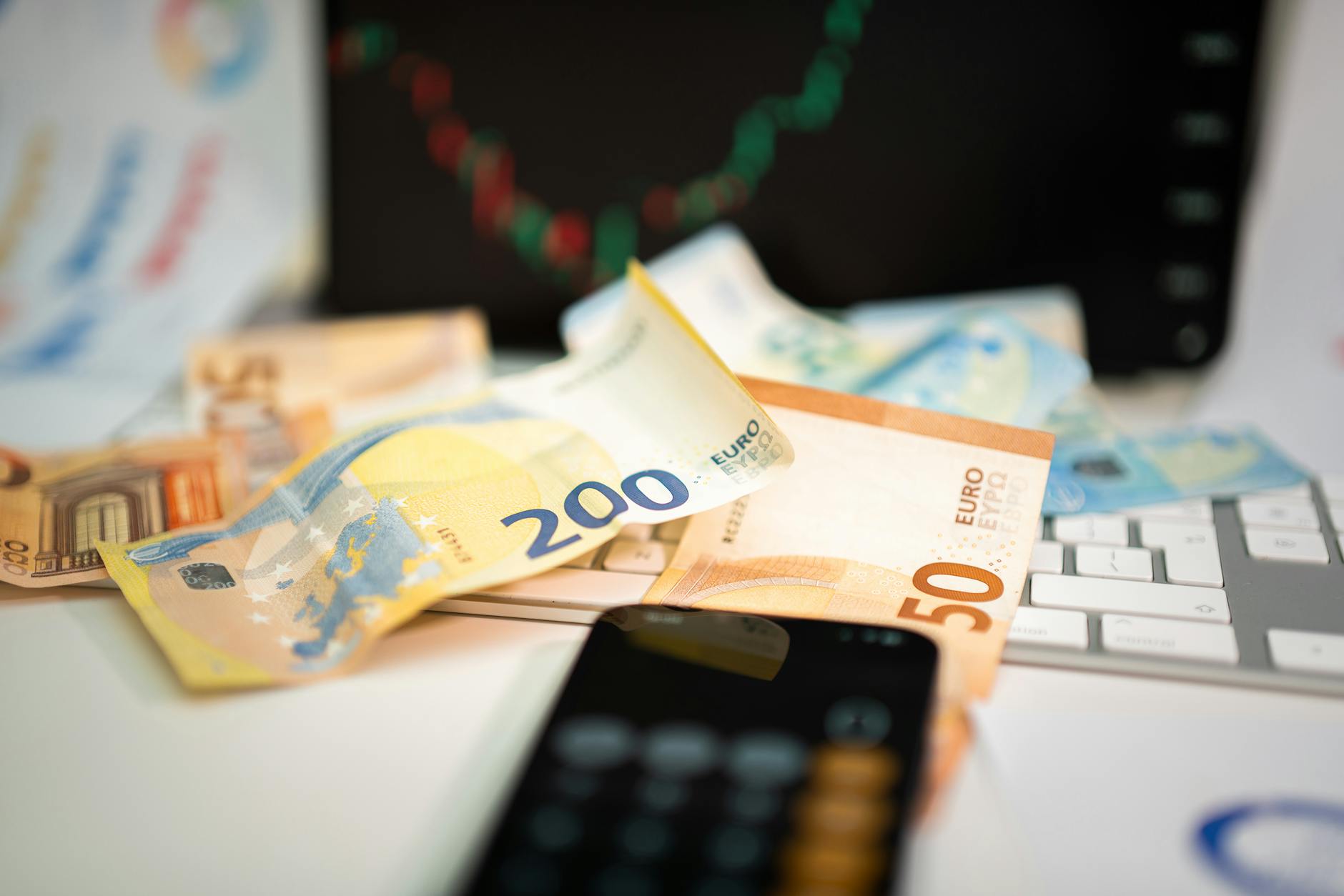 Banknoty euro i smartfon na biurku jako symbol unijnych finansów