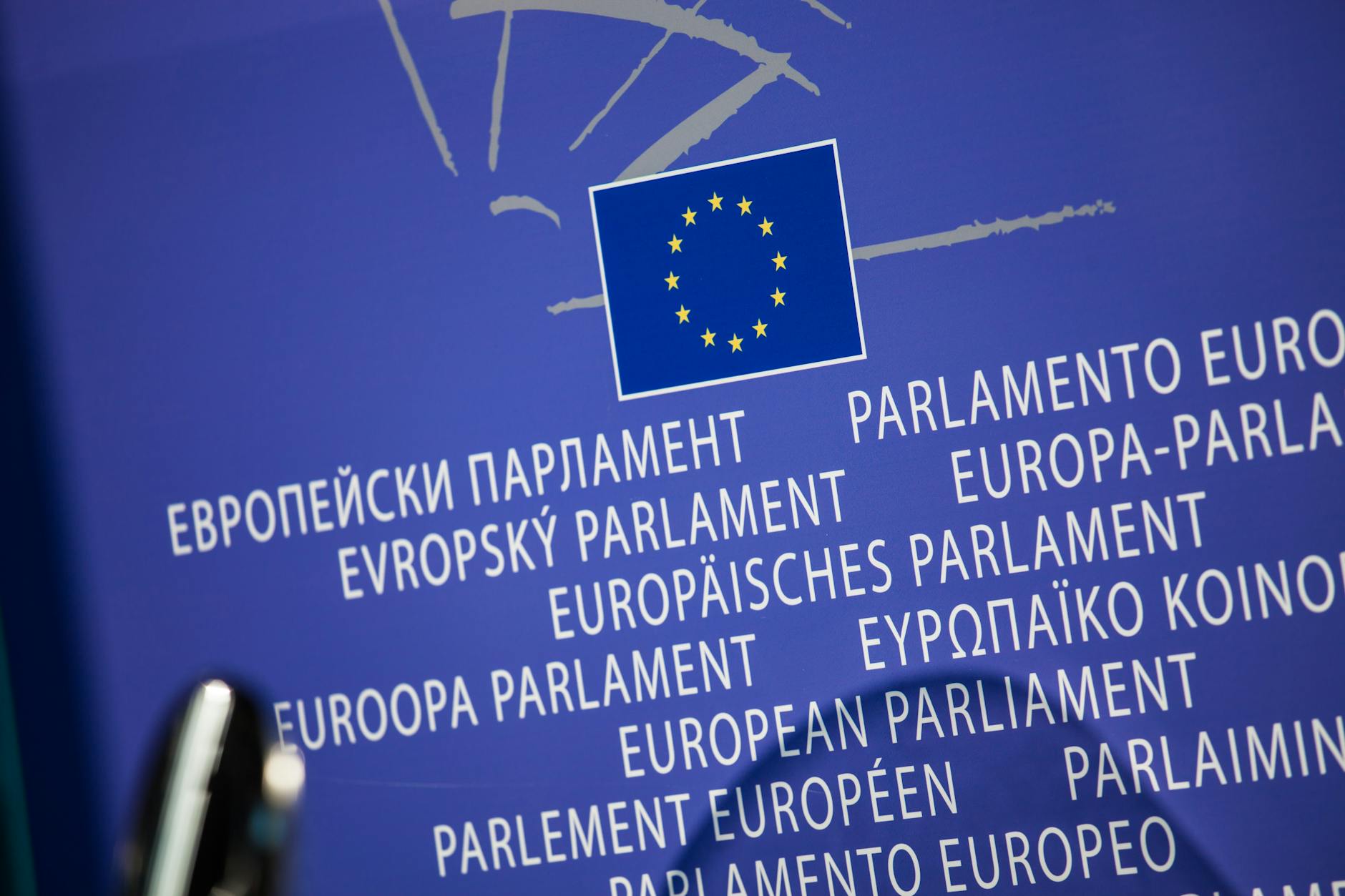 Flaga Unii Europejskiej z napisem Parlament Europejski w kilku językach