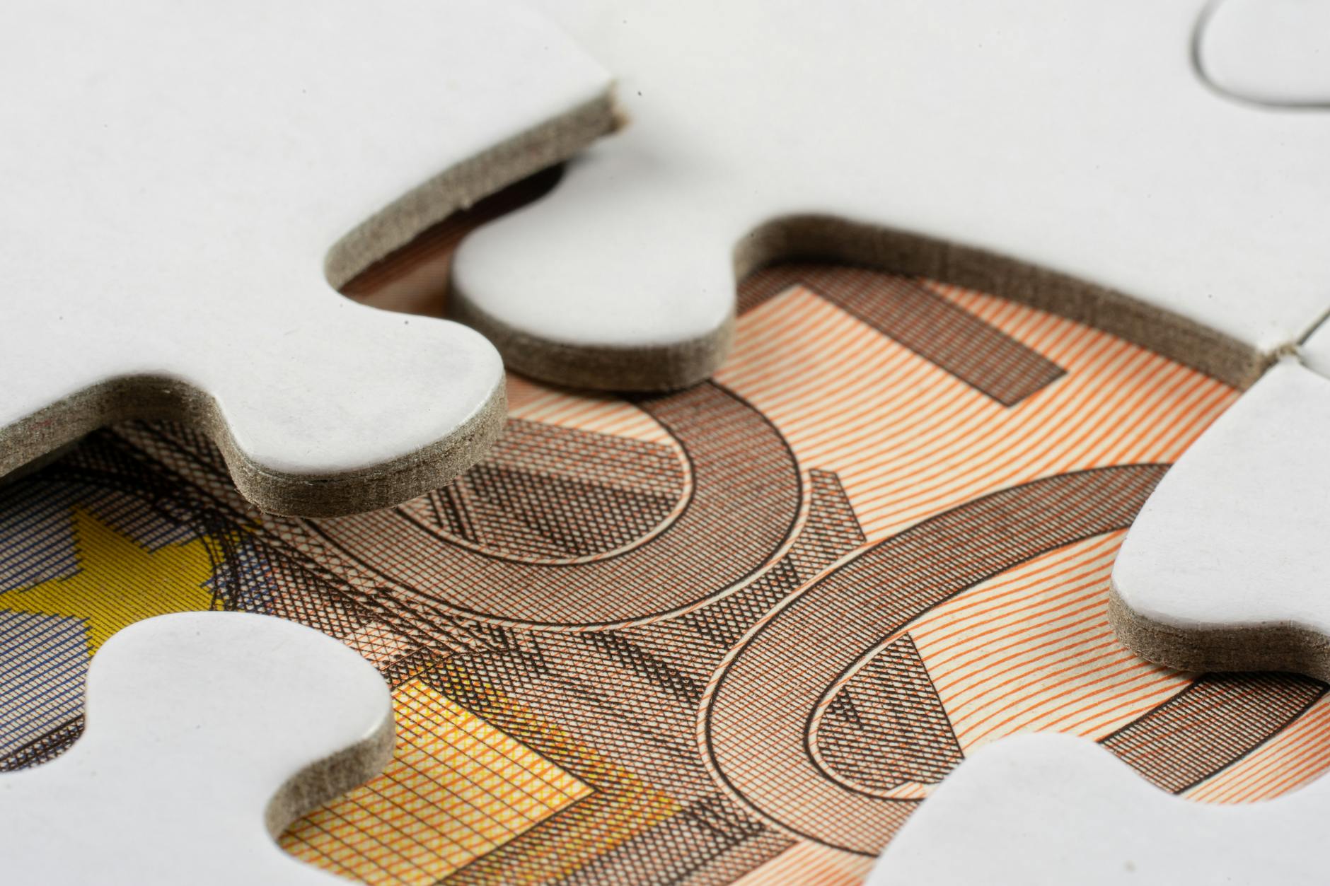 Białe puzzle na banknocie euro symbolizujące finansowanie UE
